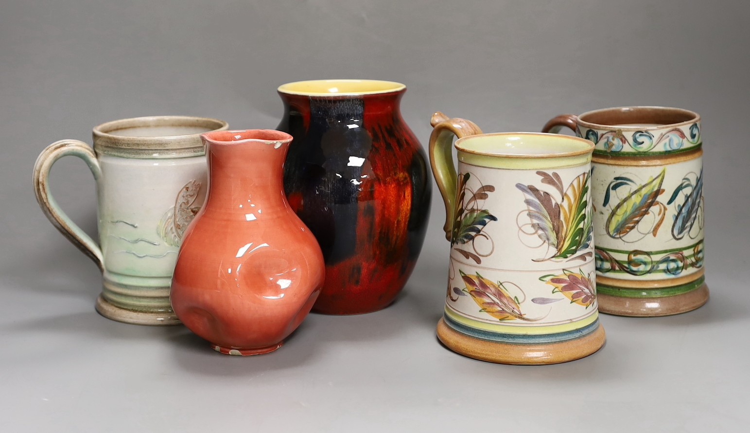 Three Glyn College jugs, a flambé Poole vase and a Burmantoft ‘White’ dimpled vase no. 989, tallest 16.5cm
